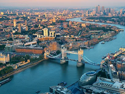 Tower Bridge and the River Thames seen from above at dusk across the London skyline