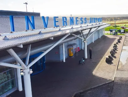 Aerial view of the Inverness Airport terminal canopy with its large blue lettering