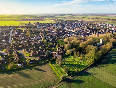 Aerial view of a village of red-roofed houses and a church among farmland in North Lincolnshire