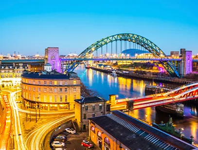 Tyne Bridge and Newcastle quayside lit up at dusk with light trails on the road