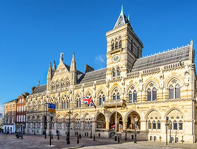 Ornate Gothic-style Northampton Guildhall with a flag under a clear blue sky