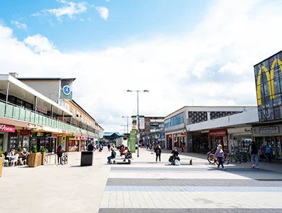 Pedestrianised shopping street with shoppers, cafe seating and shopfronts in Rutland