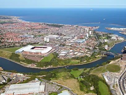 Aerial view of the football stadium beside the River Wear with the coast beyond in Sunderland