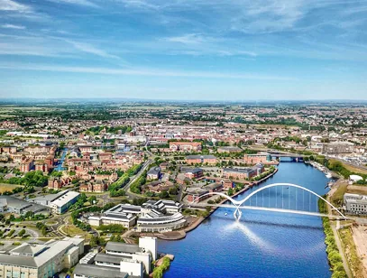 Aerial view of the River Tees with a white arched footbridge and the town beyond in Stockton-on-Tees