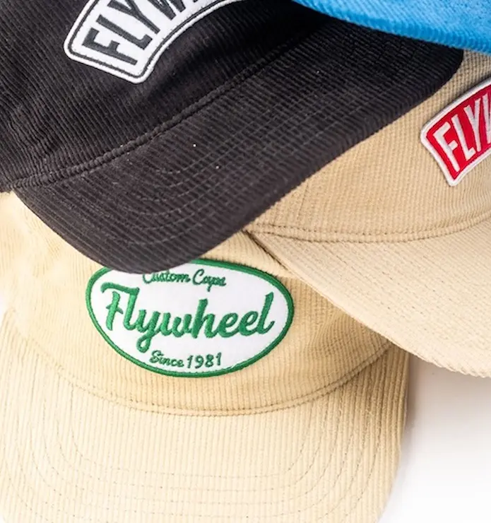 Customizable apparel, including company shirts and custom caps with logo, crafted to reflect your brand’s identity beyond logos by Flywheel Brands