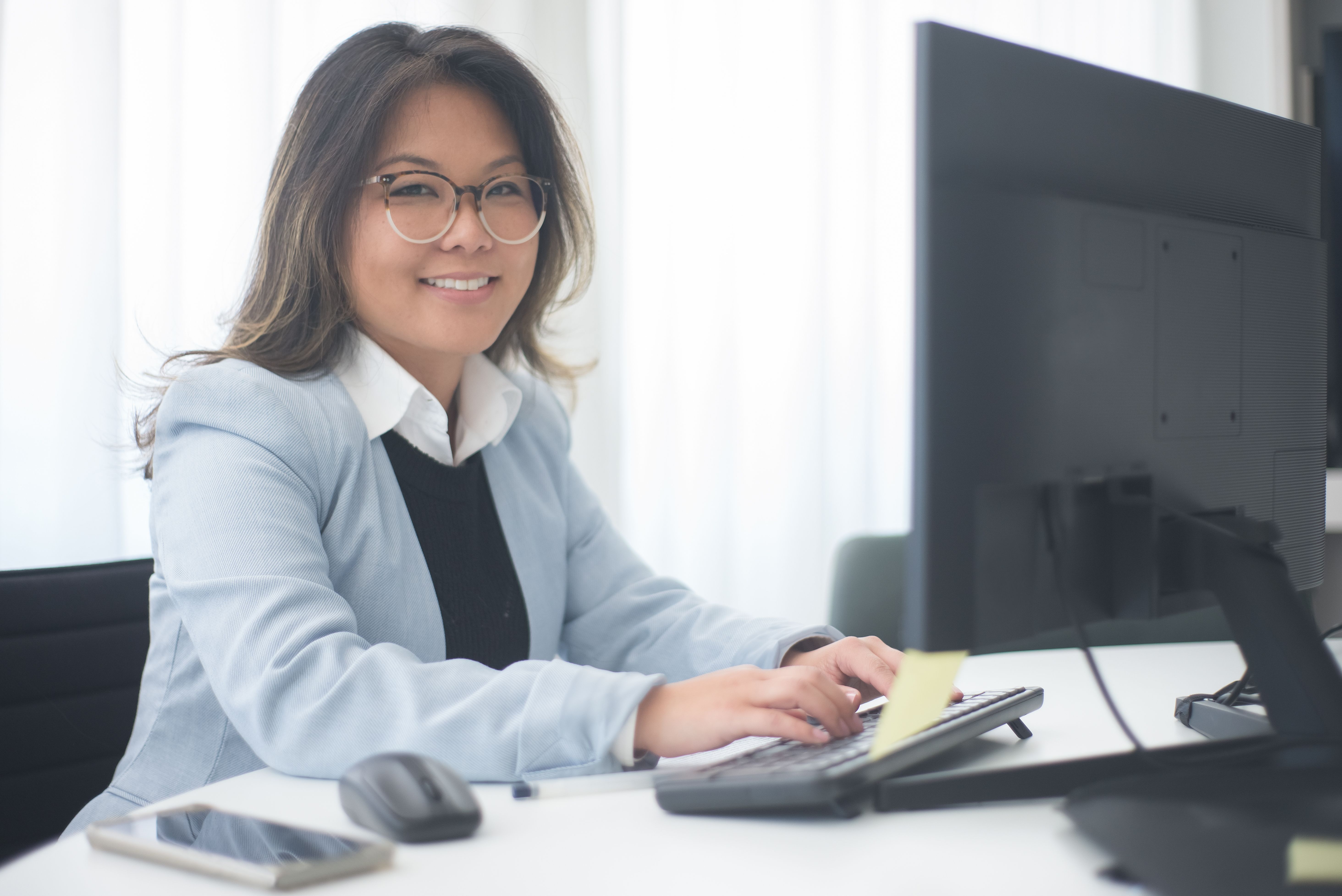 University enrollment professional managing email marketing campaigns at her desk
