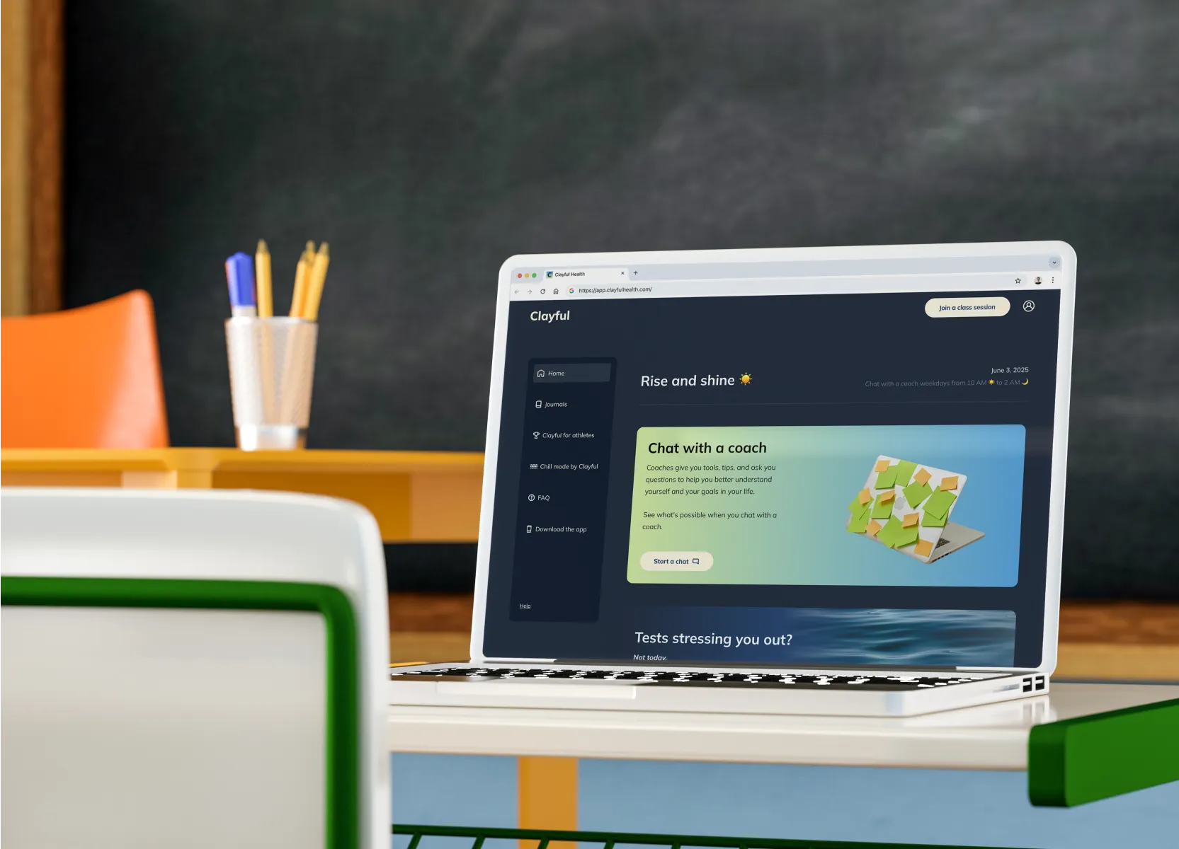 Clayful platform displayed on a laptop in a colorful classroom setting, highlighting its chat with a coach feature.