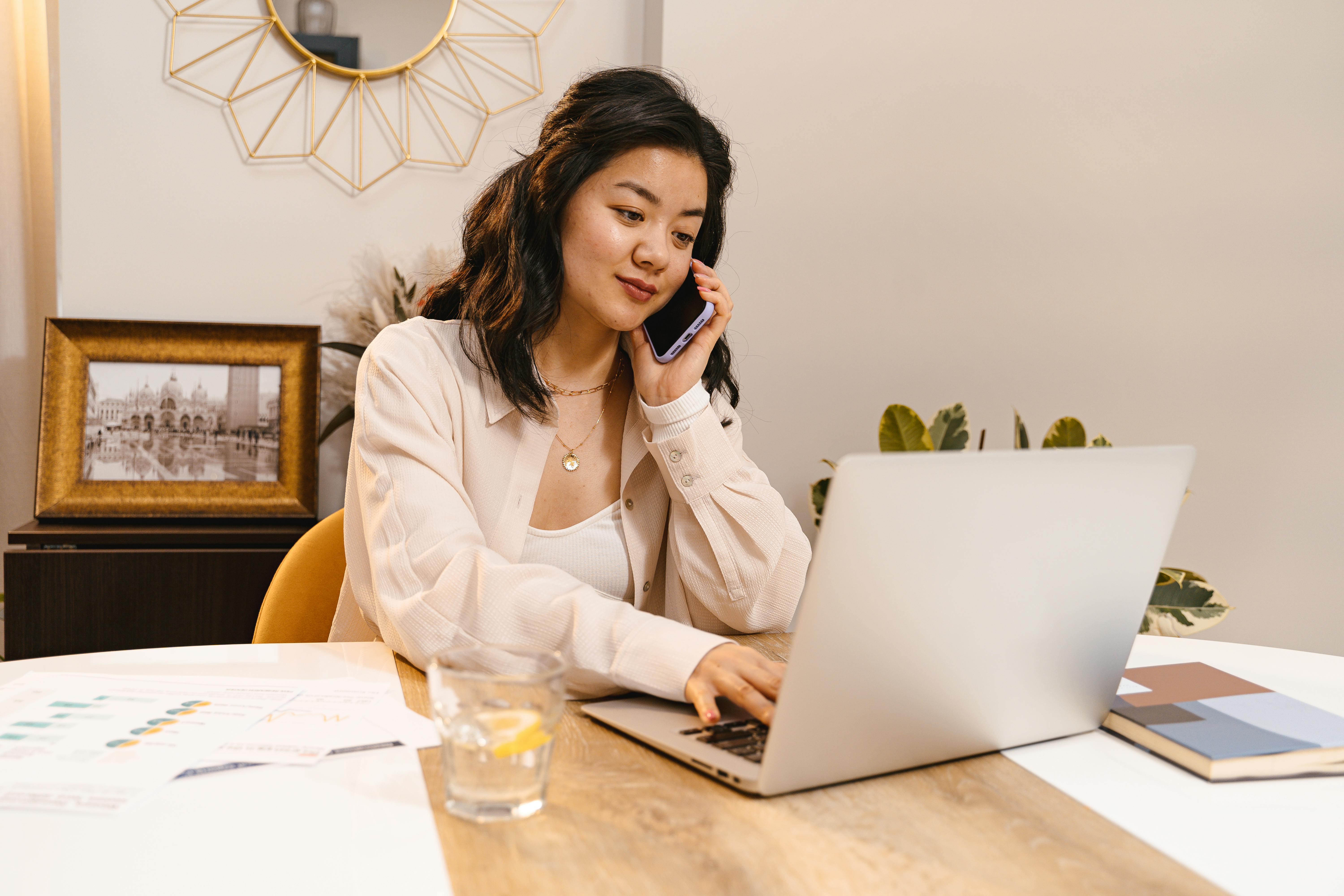 An office worker working on their laptop whilst on the phone