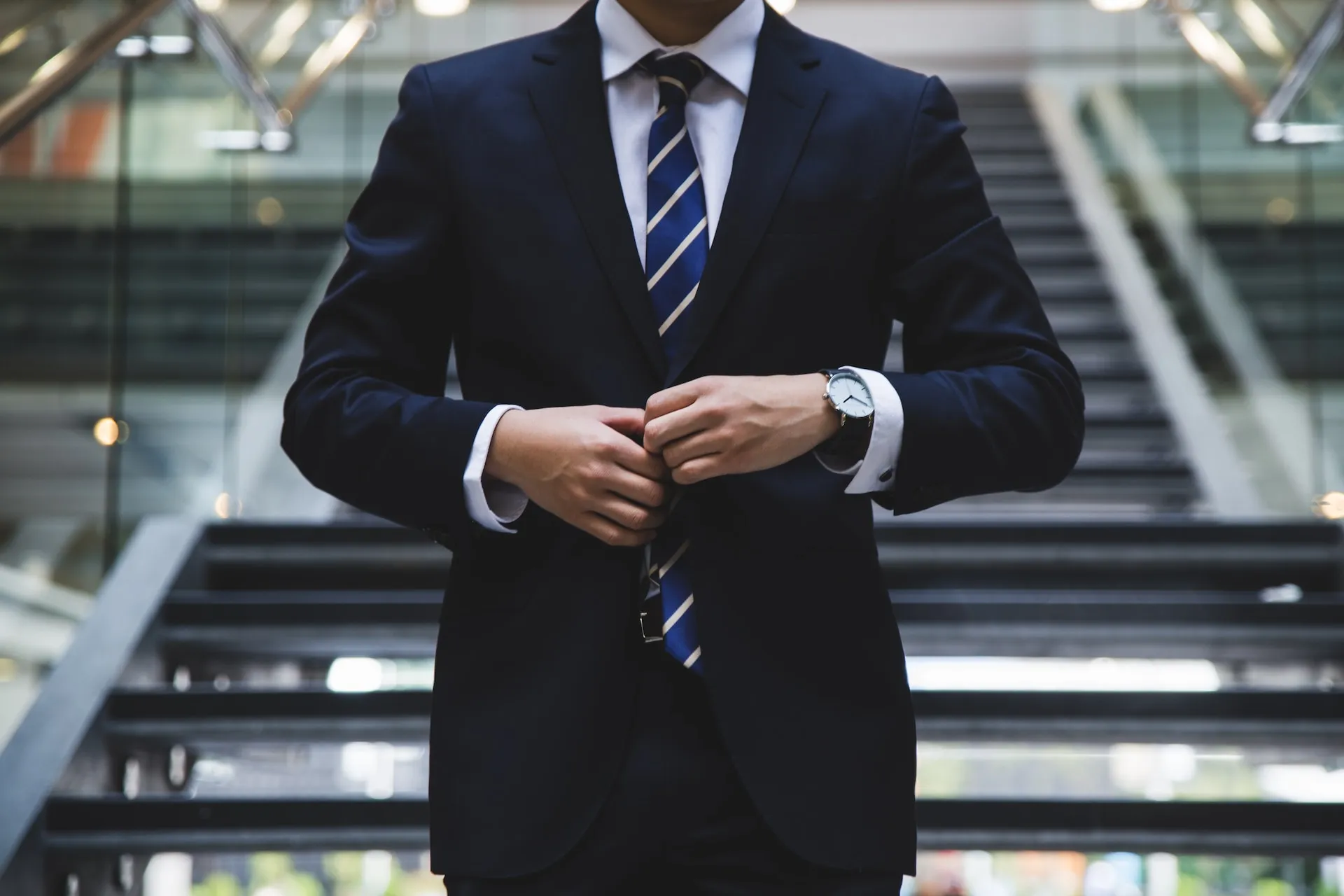 A company director in a suit adjusting his jacket