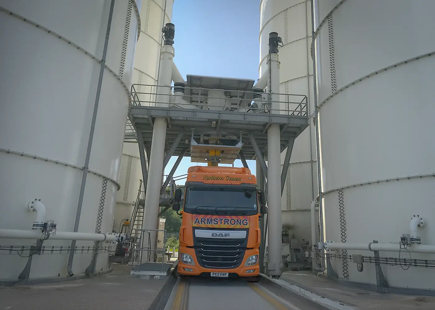 Cement delivery truck loading at terminal silo facility