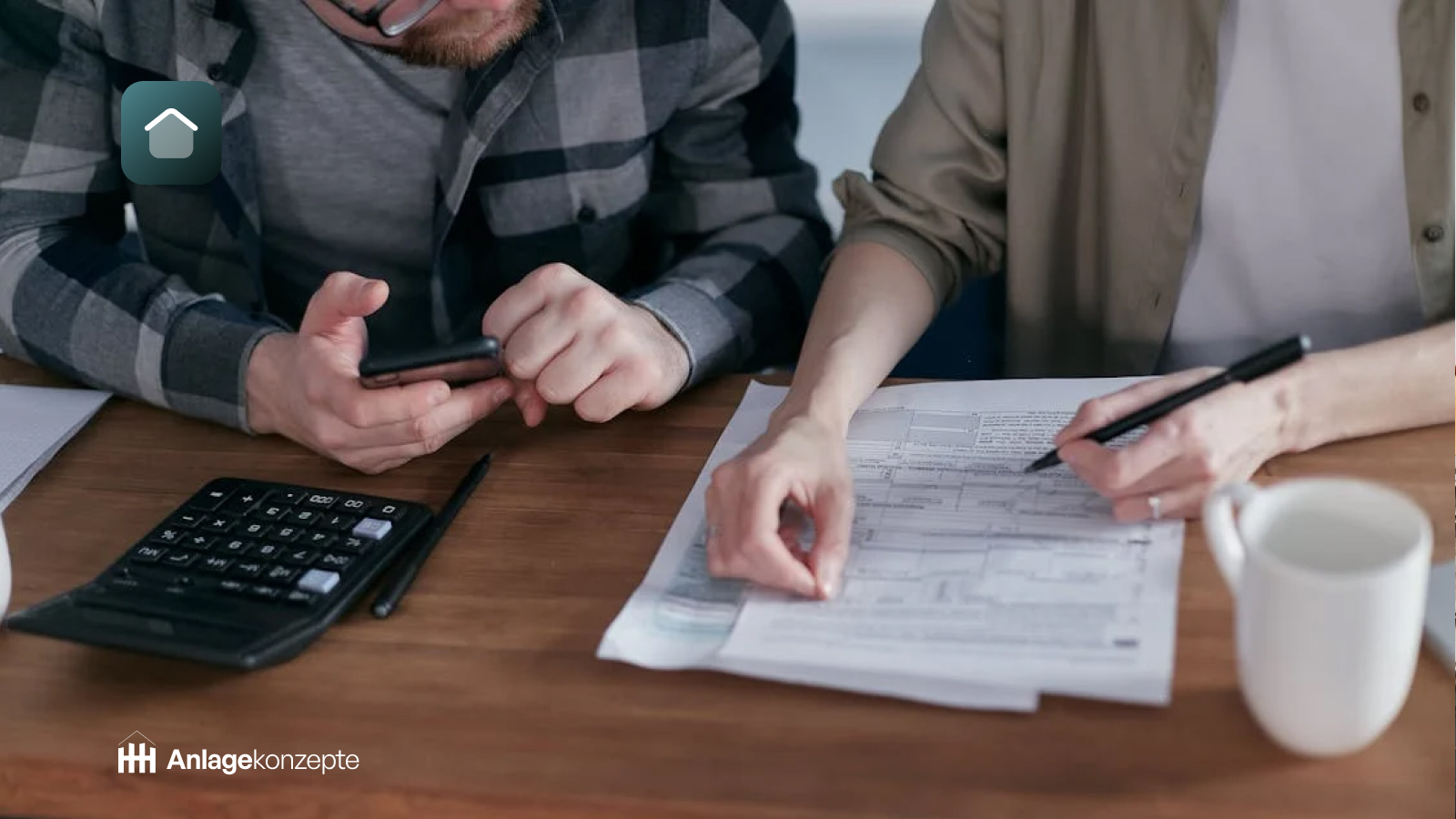 Zwei Personen arbeiten an Immobilien-Anlagekonzepten in Deutschland, mit Dokumenten, einem Taschenrechner und einem Smartphone auf einem Tisch, während sie Finanz- und Steuerplanung für Immobilieninvestitionen besprechen. Haus-Symbol und Anlagekonzepte-Logo im Vordergrund