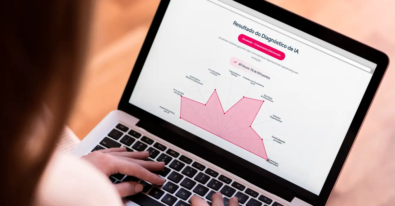 Pessoa usando um laptop que exibe um gráfico radial rosa com resultados do Diagnóstico de IA, destacando pontuação ATI Score: 78 de 100 pontos e áreas como Estratégia, Cultura e Governança.