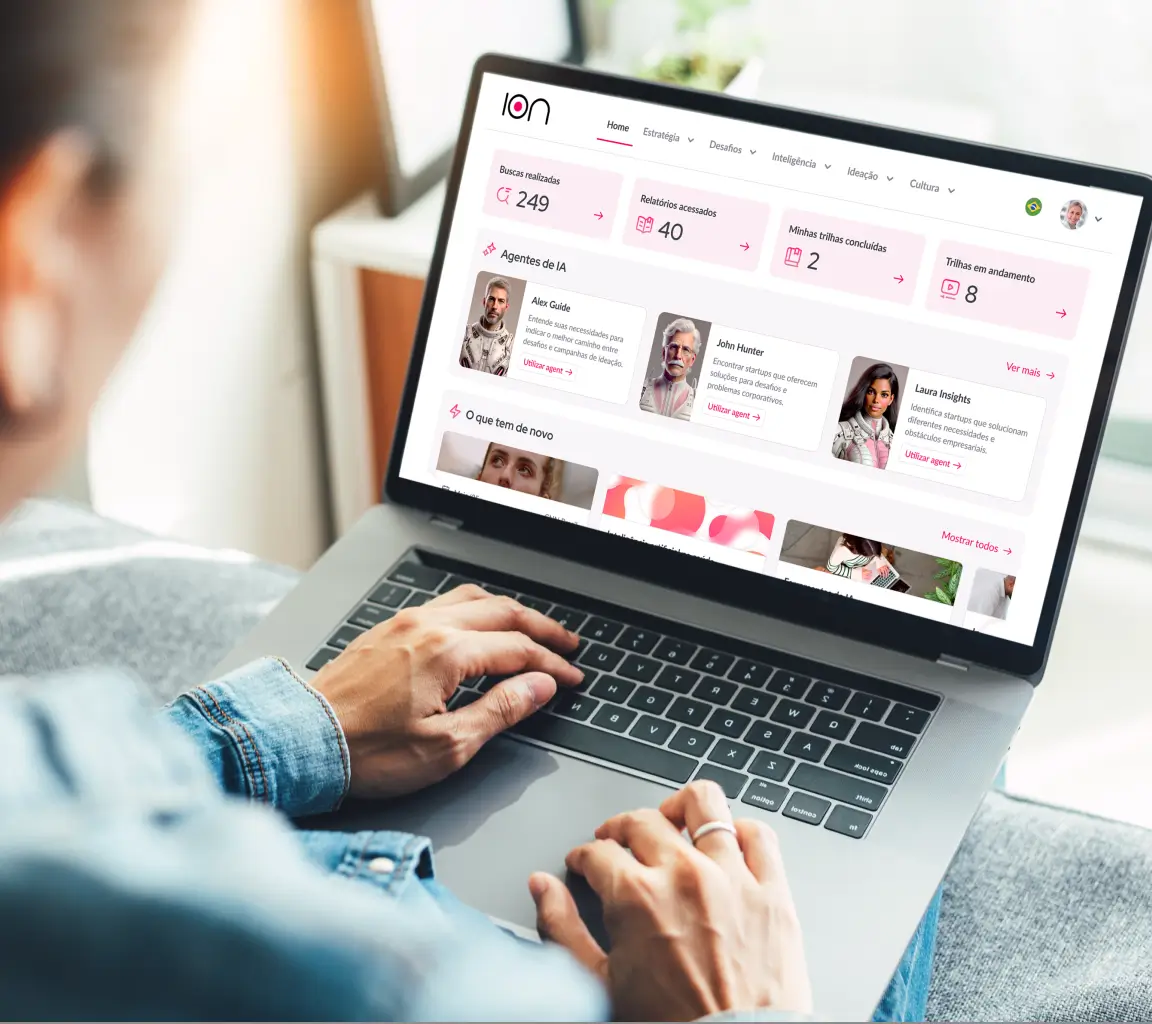 Pessoa usando laptop mostrando dashboard da plataforma ION com estatísticas, agentes de IA e trilhas de aprendizado.