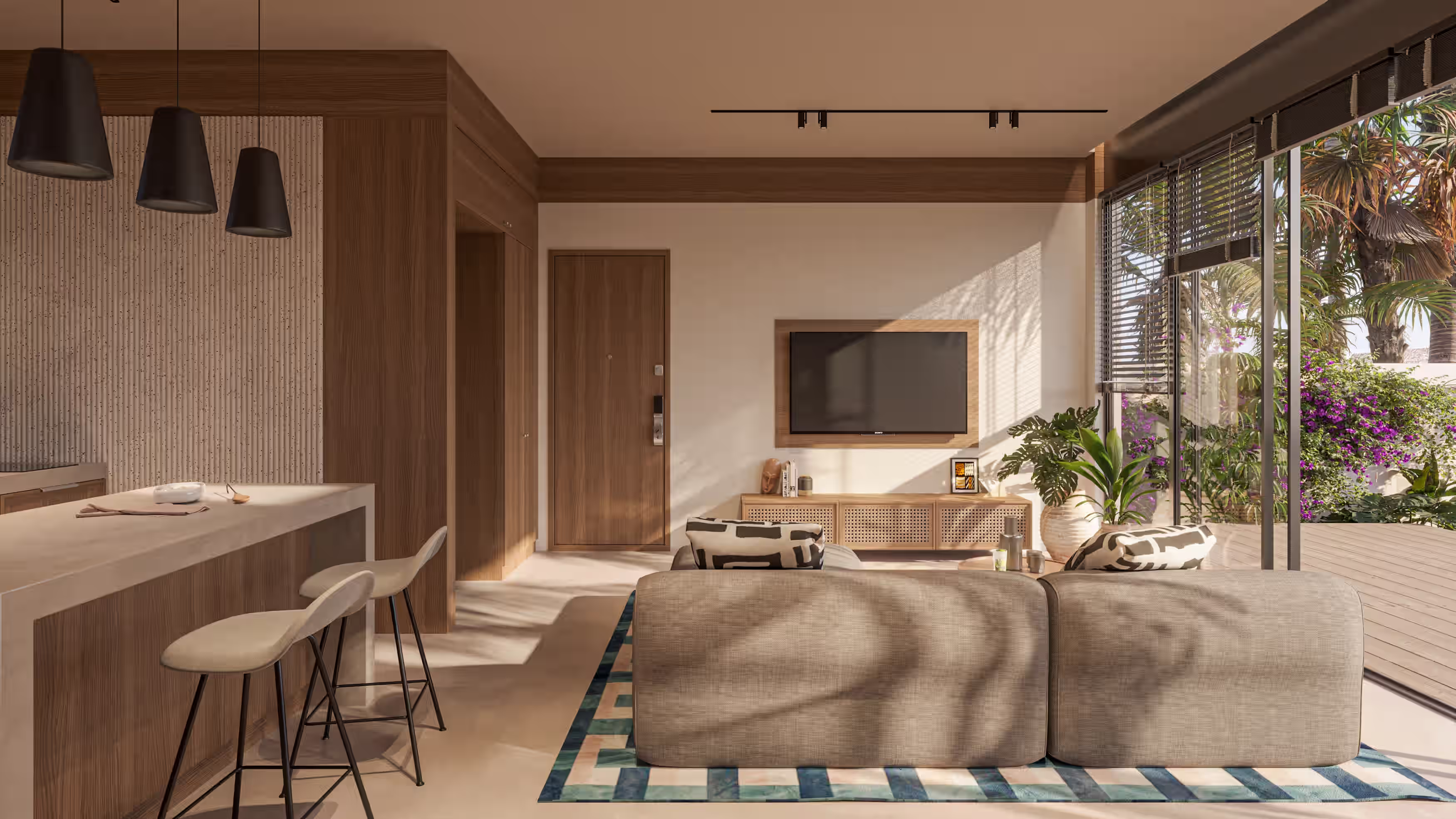 Villa living room with kitchen island, sliding glass doors and a planted terrace beyond