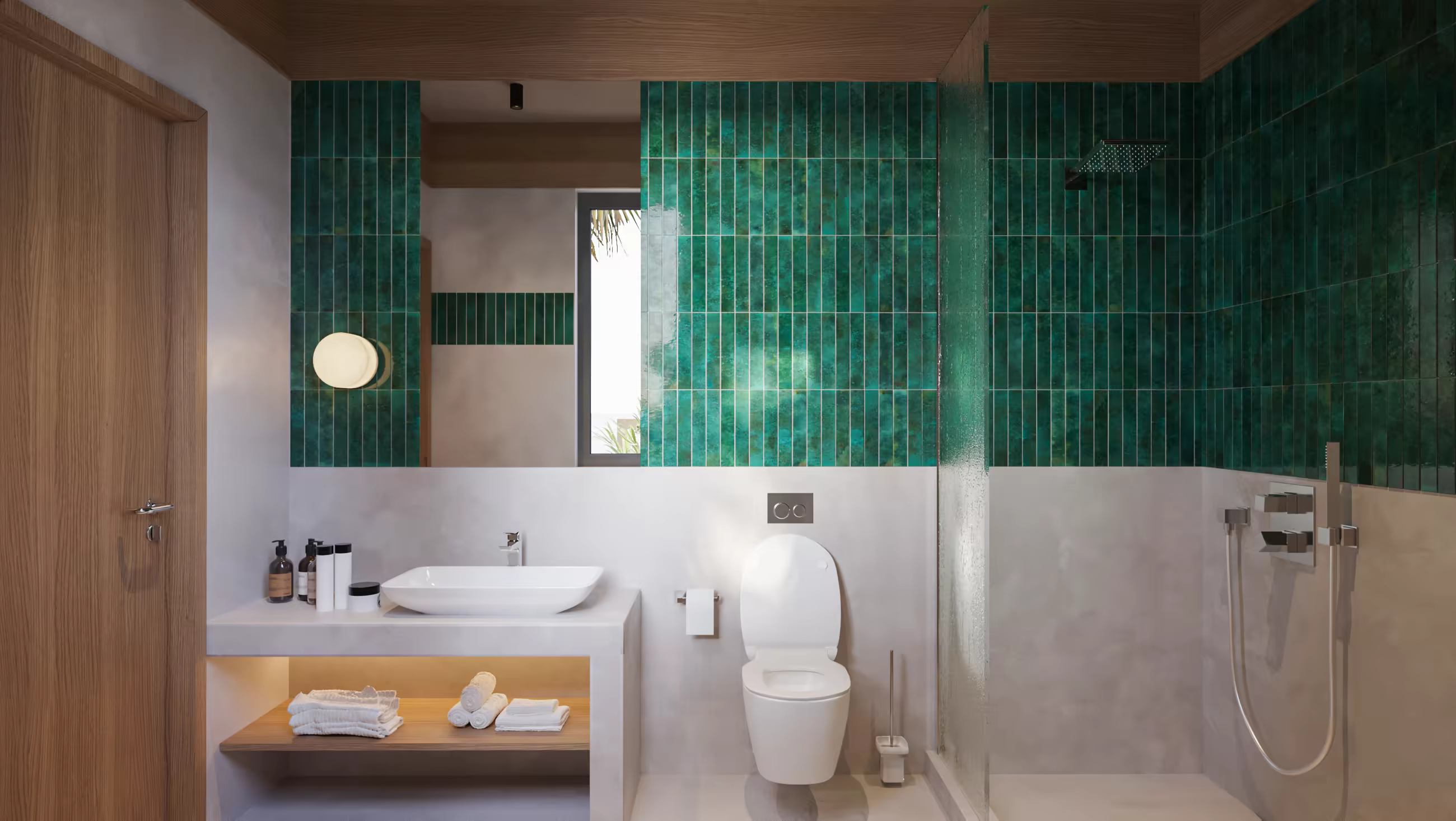 Modern bathroom with green tiled shower wall, white toilet, and sink on a white vanity with towels.