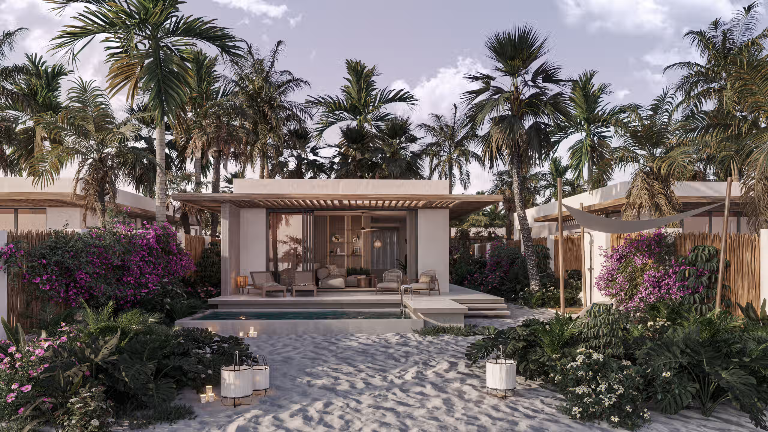Modern beachside villa with pool, surrounded by palm trees, flowering bushes, and sand pathway.