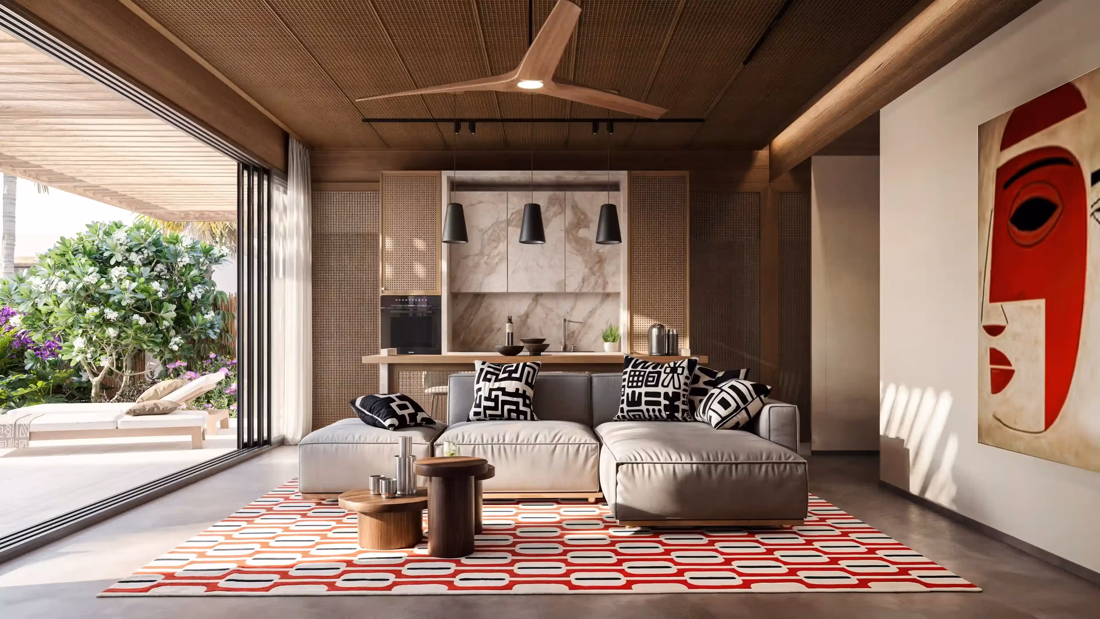 Modern living room with beige sofa, patterned pillows, red geometric rug, and open view to garden patio.