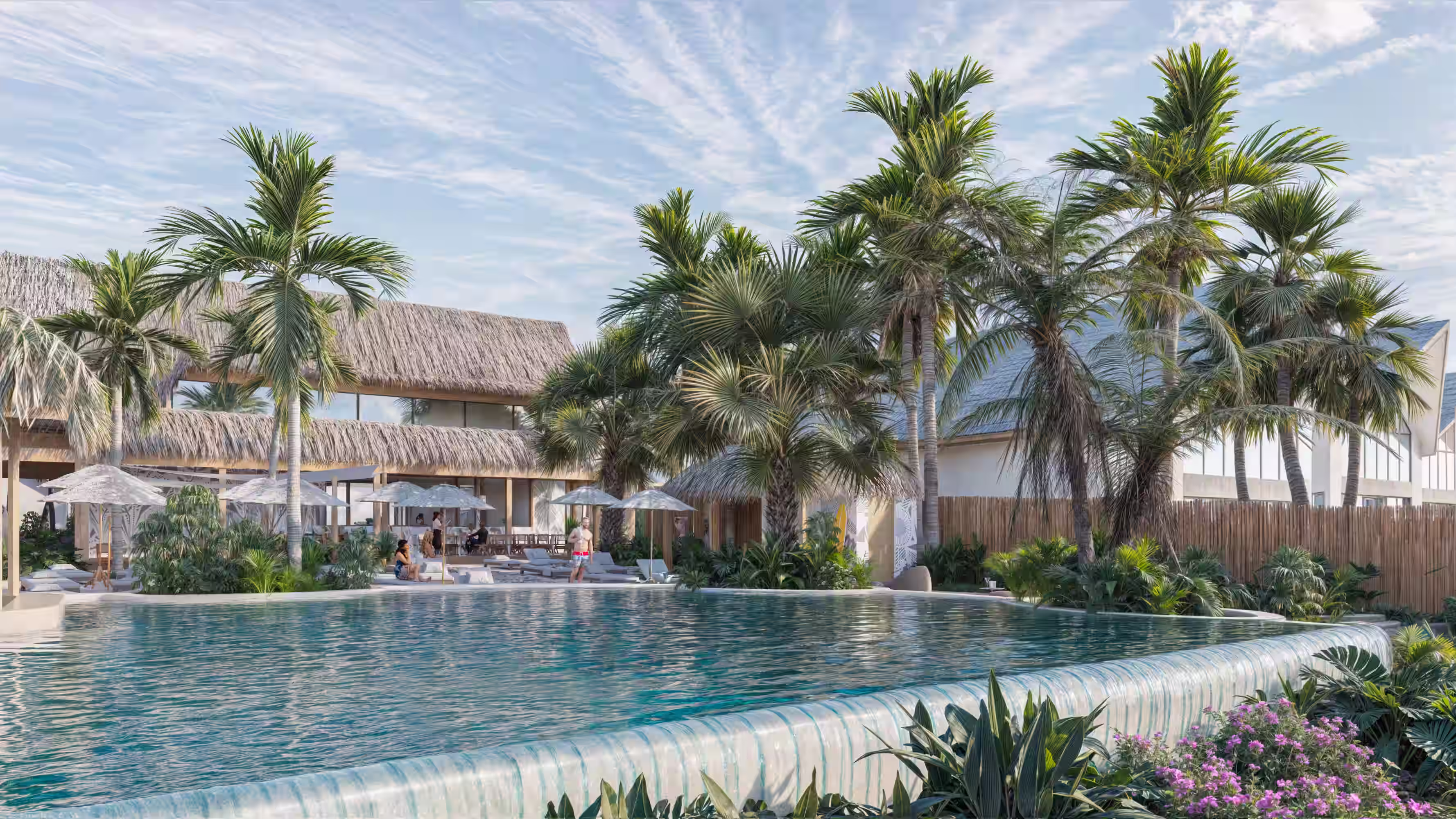 Infinity pool with water spilling over edge surrounded by palm trees and lounge chairs under umbrellas.