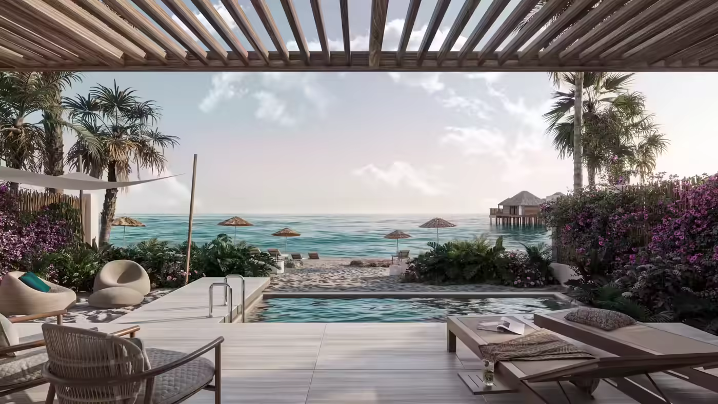 Oceanfront patio with pool, lounge chairs, palm trees, and thatched beach umbrellas on sandy shore.