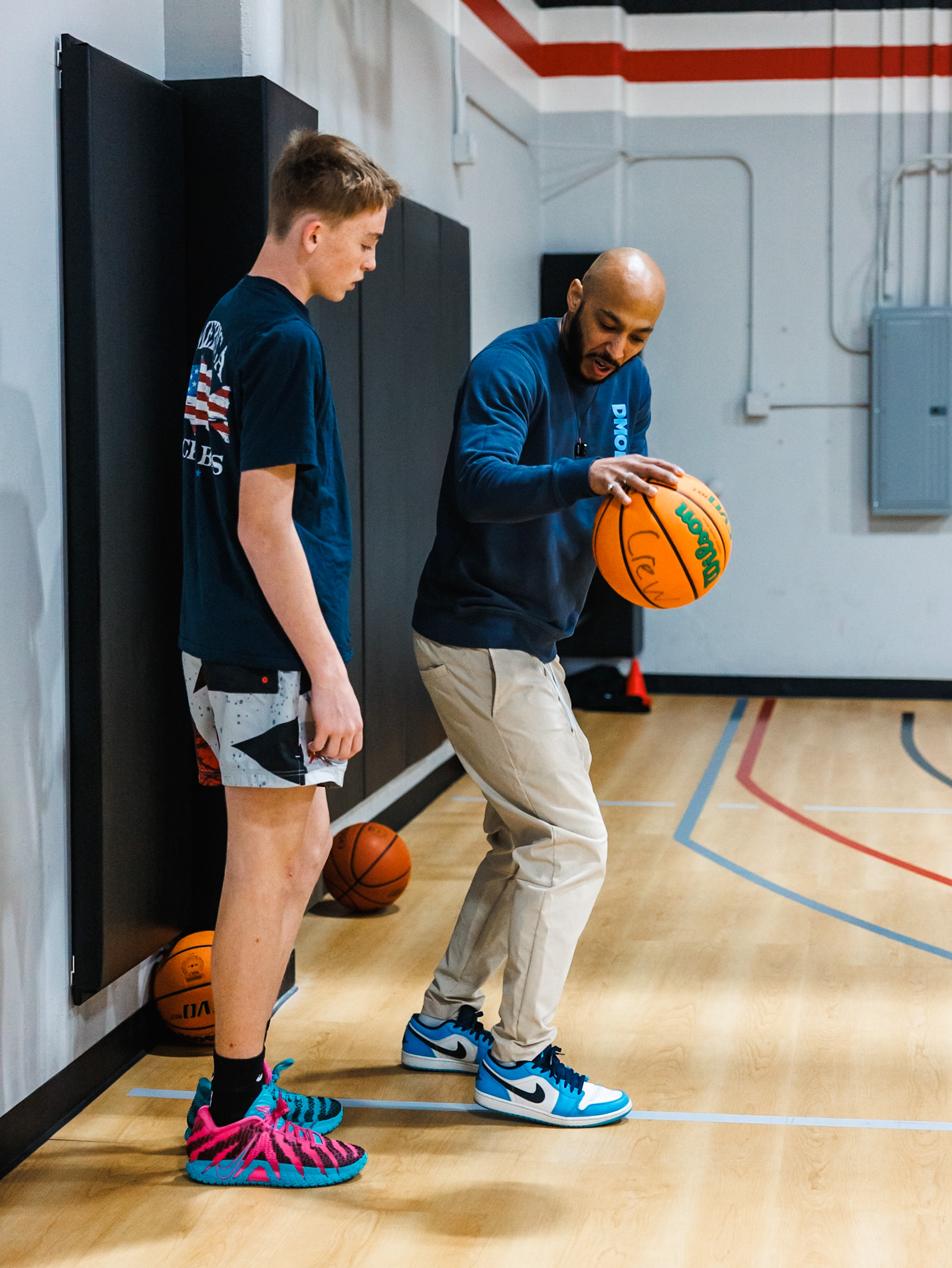 Basketball coach offering personalized coaching and feedback to a player at Shoot 360 San Mateo.