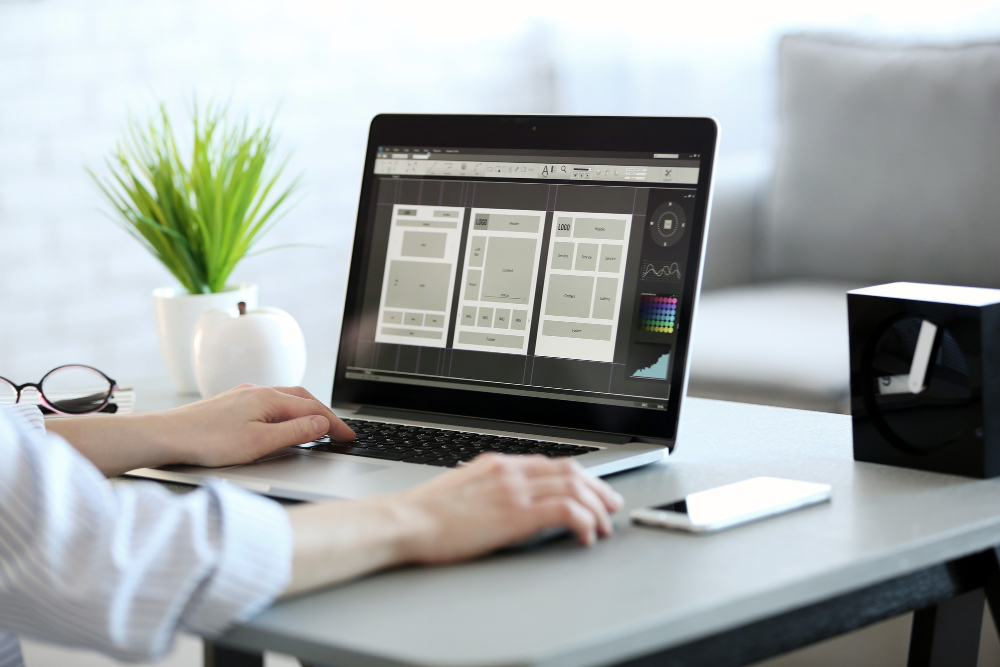 A web designer adjusting colour palettes and layouts for a modern website interface.