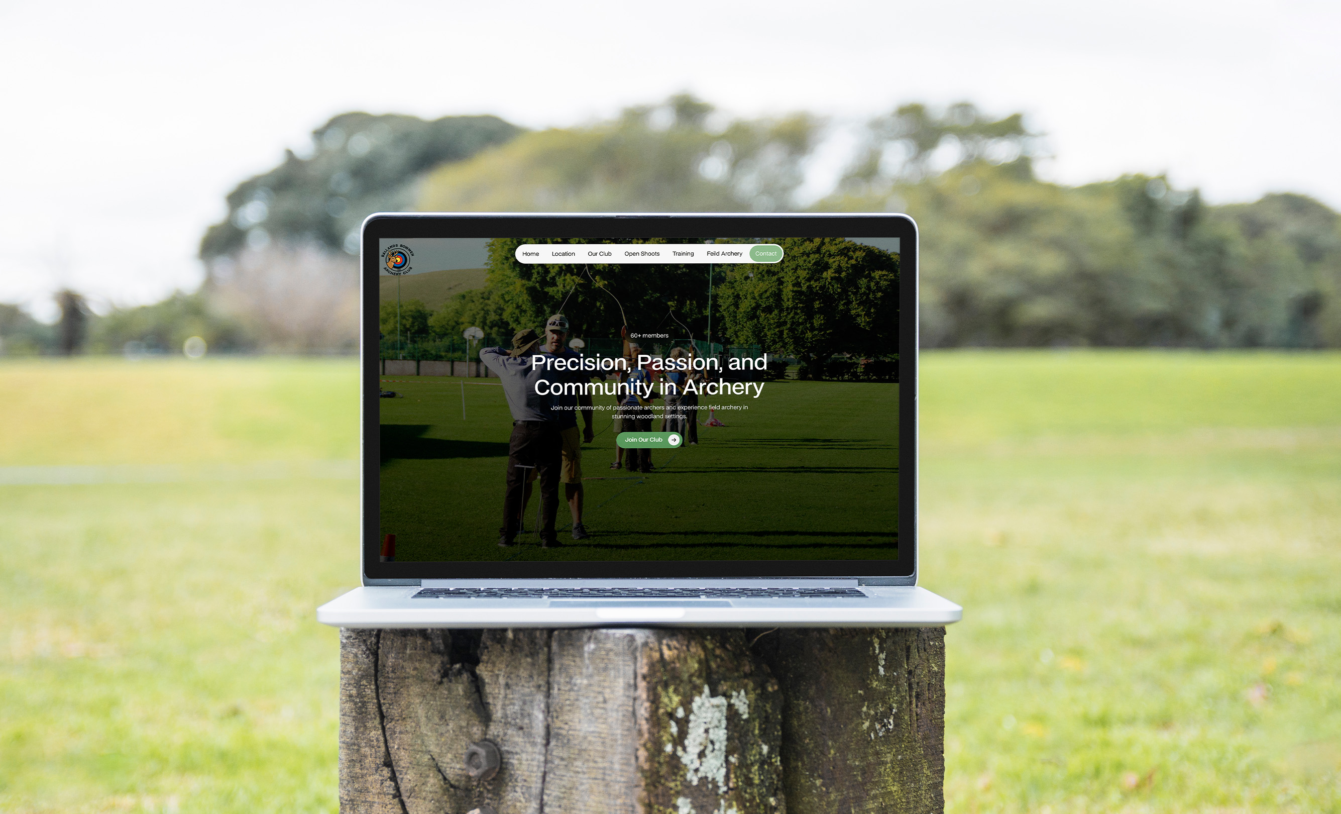 Laptop displaying the Ballands Bowmen Archery Club website featuring a green woodland-inspired design and archery imagery.
