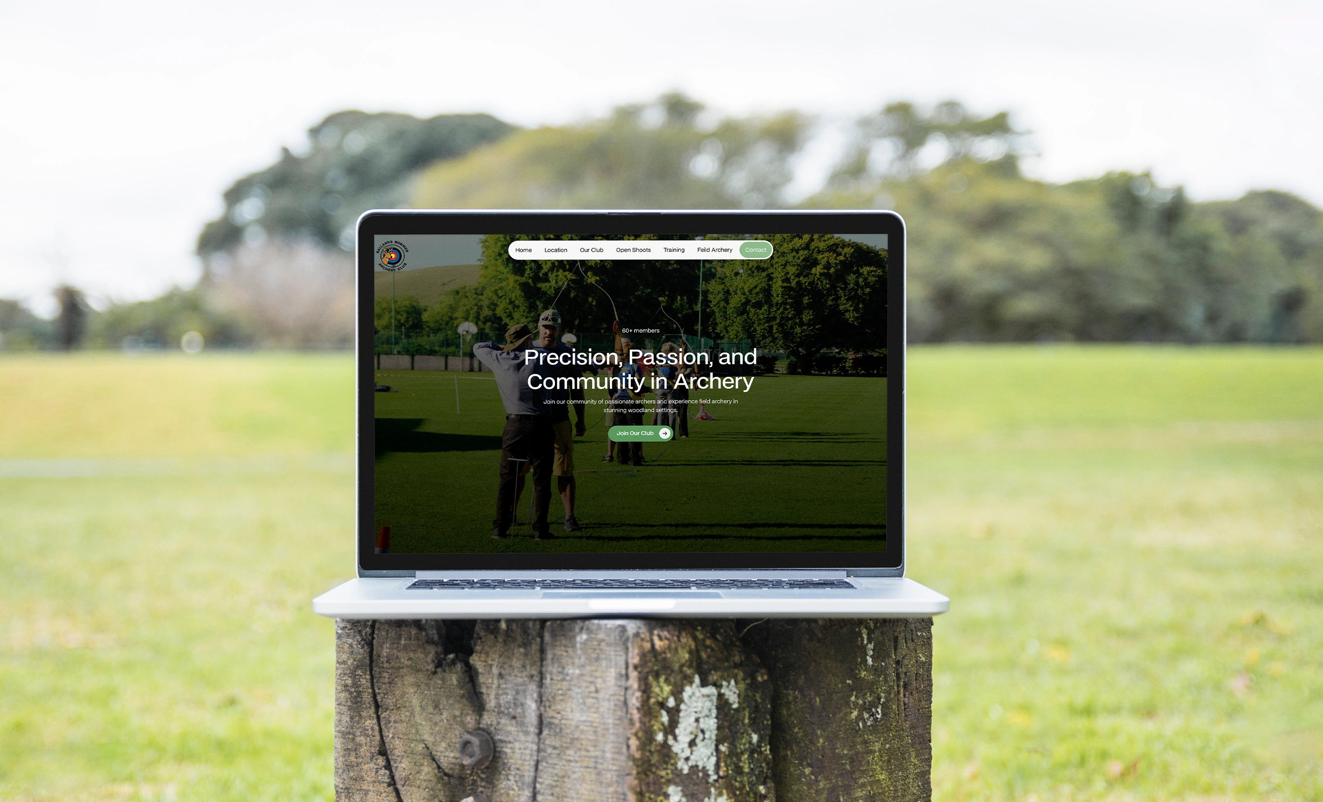 Laptop displaying the Ballands Bowmen Archery Club website featuring a green woodland-inspired design and archery imagery.