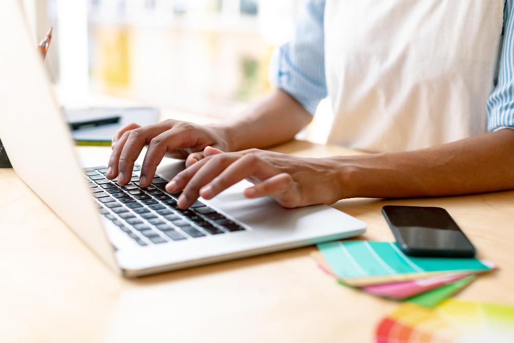 Small business owner in Dorset working on a laptop to improve their online presence and compete with larger brands.