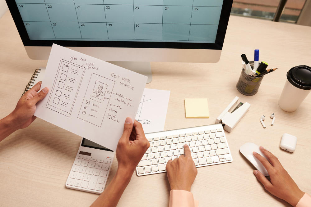 Designer planning website wireframes and notes while preparing for a website redesign.