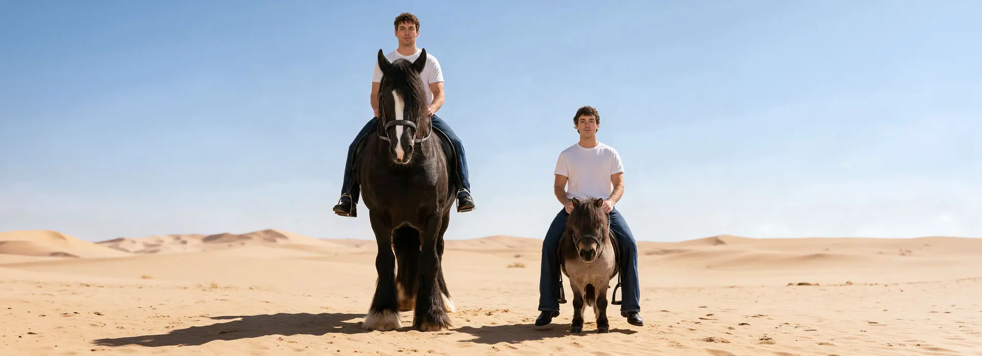 Zwei Männer in weißen T-Shirts und blauen Jeans reiten nebeneinander in einer sandigen Wüstenlandschaft: der linke Mann auf einem großen schwarzen Pferd, der rechte auf einem kleinen Pony.
