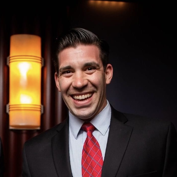 Color photo of Dan Fuoco, smiling in a suit and tie. 