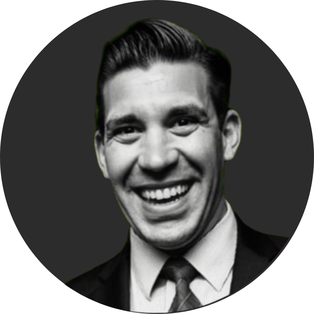 Black and white photo of Dan Fuoco, smiling in a suit and tie. 