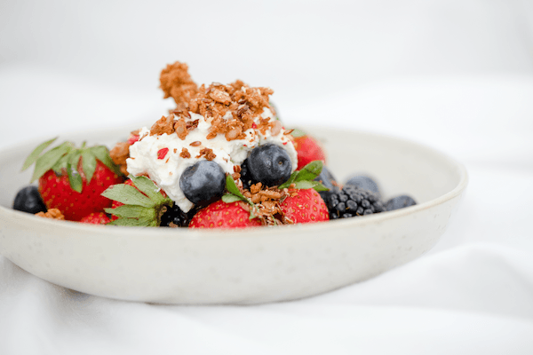 A bowl of Greek yoghurt sprinkled with berries as a healthy choice for menopause diet 
