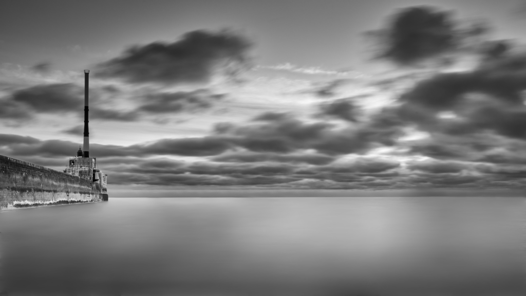 Une photo en noir et blanc d'une mer calme, lisse. L'entré du port du Havre, classé 17ème au concours photo WinSPOT by Data Concept 2023-2024