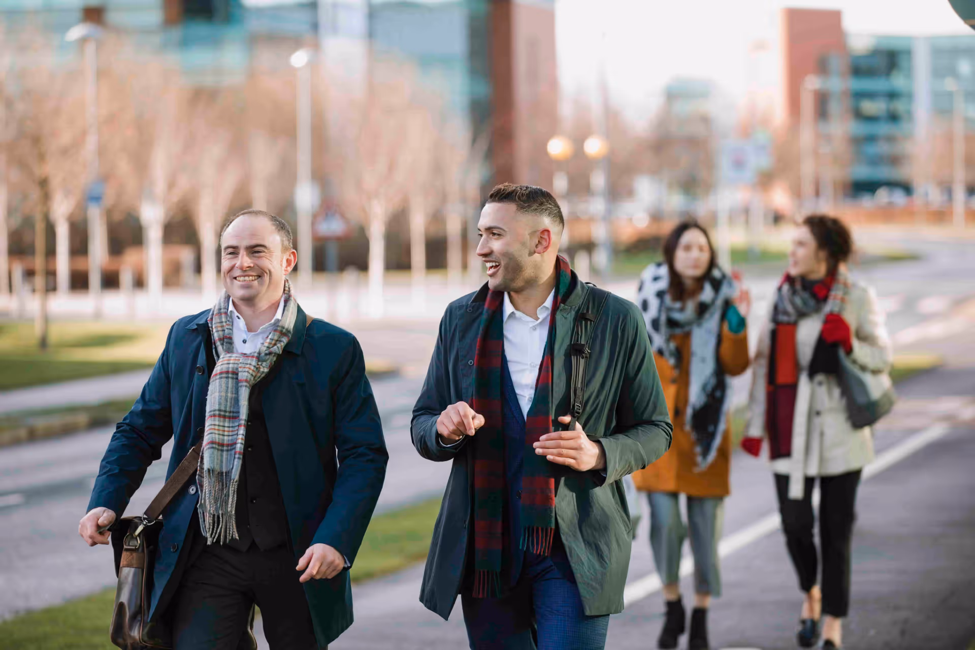 Two men and two women walk to work on a city street