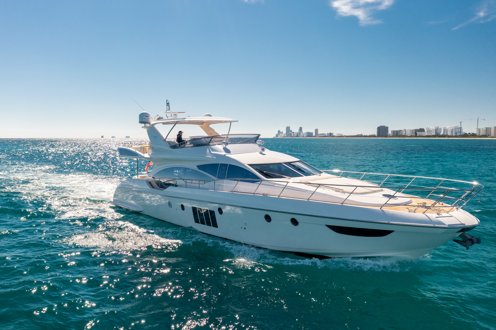 A catamaran is securely docked at the marina, surrounded by calm waters and a clear blue sky.