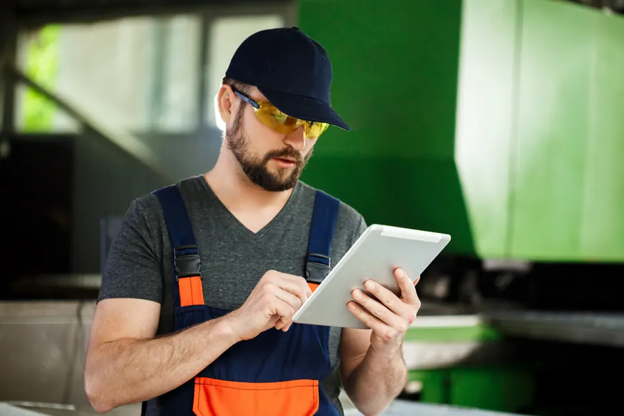 A maintenance technician checking readings at a plant workstation