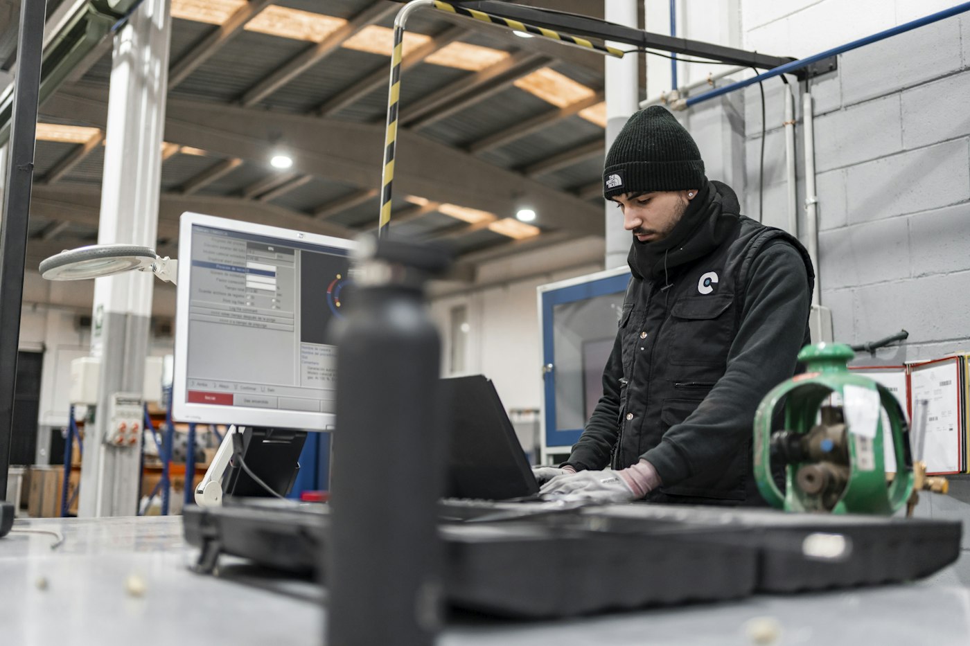 A maintenance technician checking readings at a plant workstation