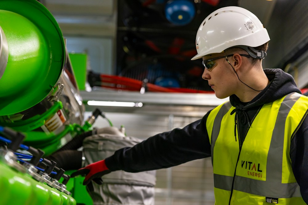 A young technician in a hard hat checking equipment