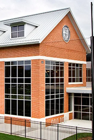 Modern brick building with large glass windows and white metal roof