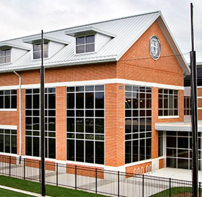 Modern brick and glass building with white roof and large windows
