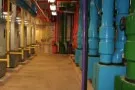 Industrial corridor with colorful blue and yellow pipes along walkway