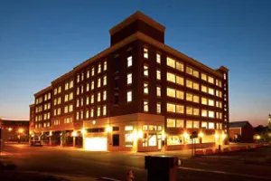 Modern multi-story building illuminated at night with warm glowing windows