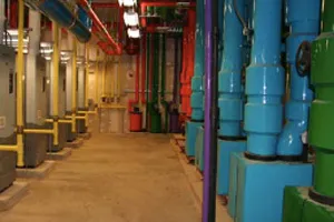 Colorful industrial corridor with blue, green, and yellow pipes