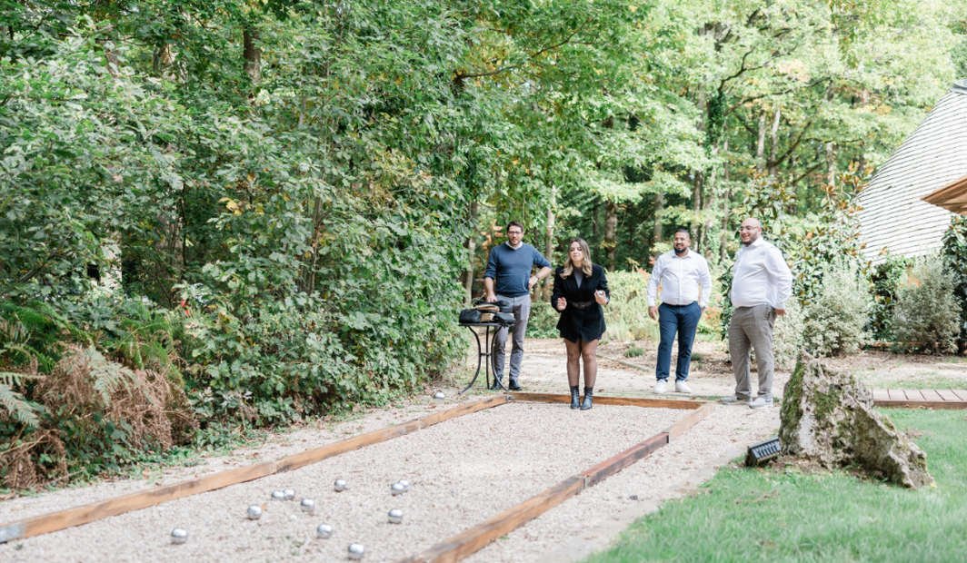 Colleagues playing pétanque outdoors during a team building activity in a private estate.