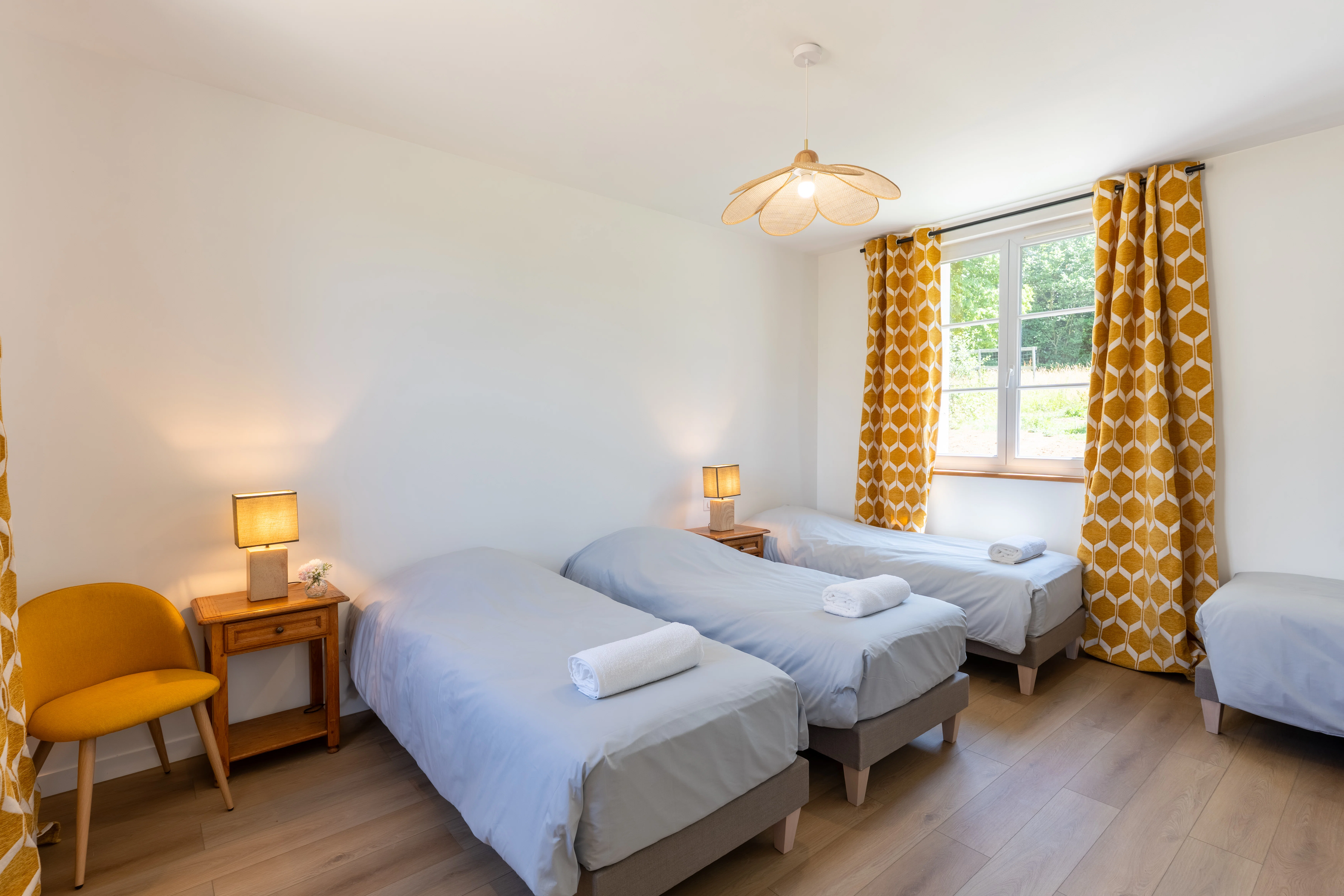 Quatre lits simples dans une chambre spacieuse du Domaine du Grand Morin.