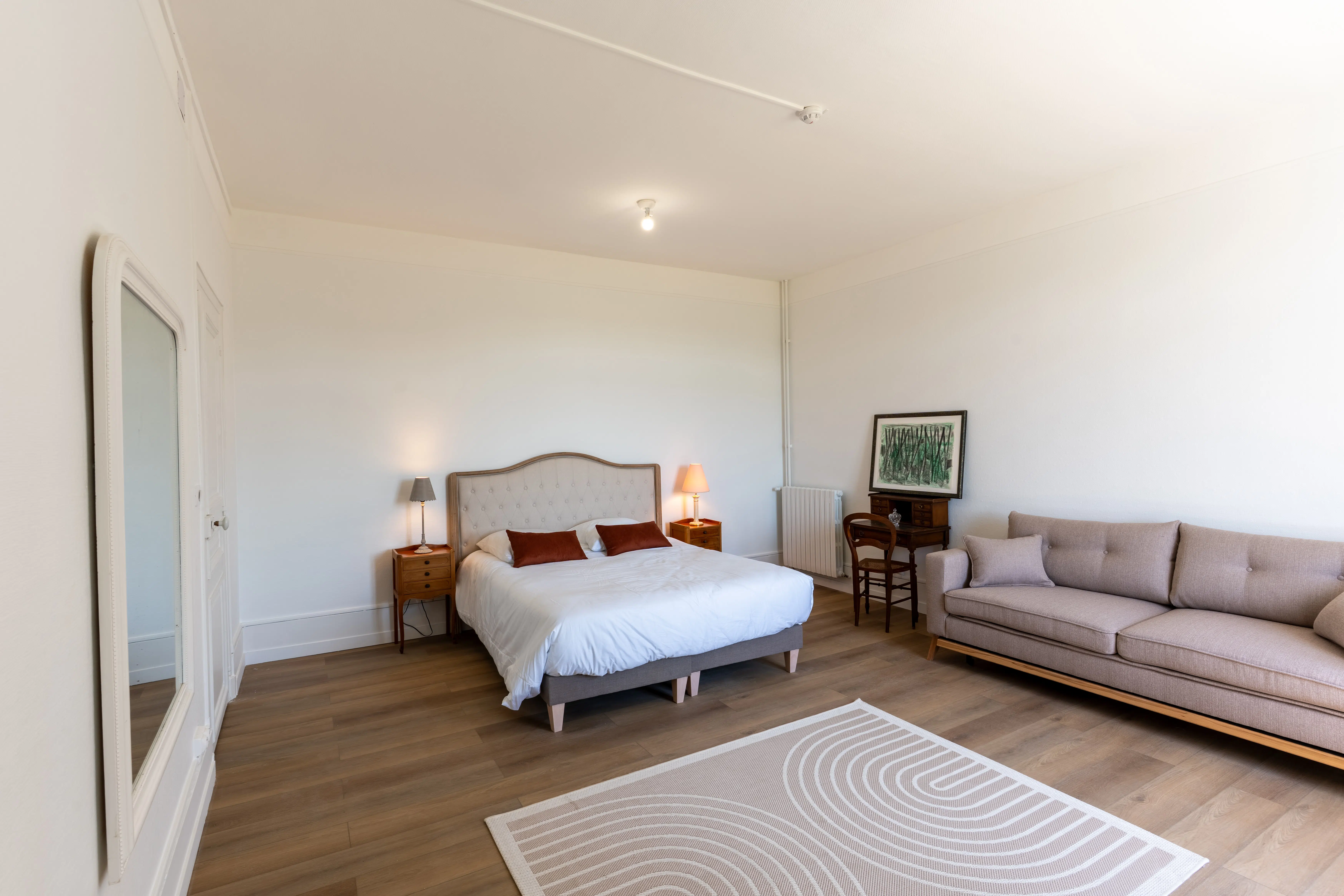 Lit et canapé dans une chambre spacieuse du Domaine du Grand Morin.