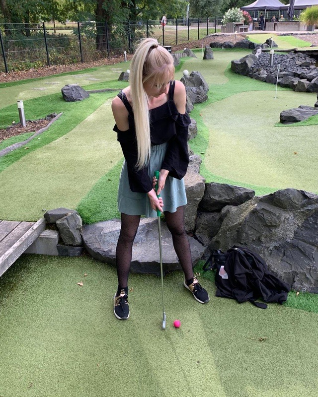 A team member playing mini golf