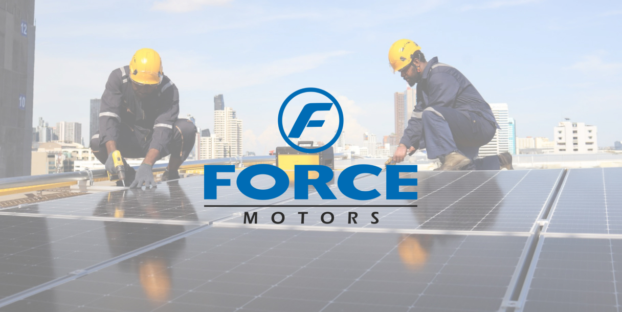 Two men working on a solar panel with the force motors logo in the background.