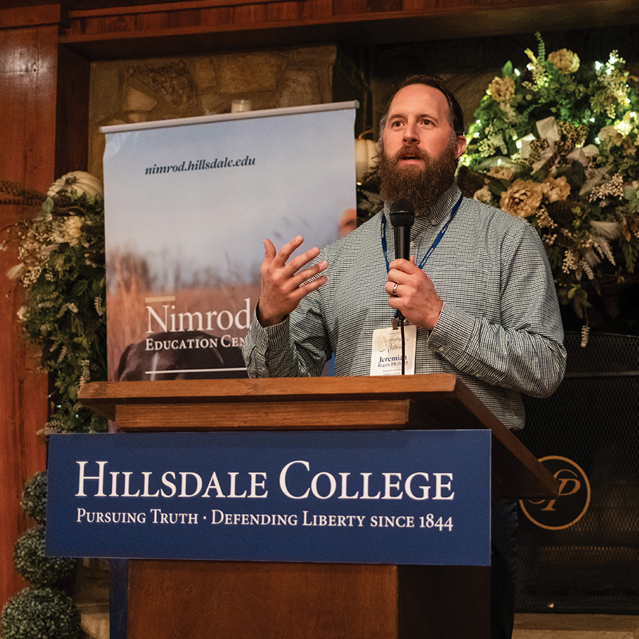 A speaker at a podium speaks to participants at speech held in a lodge.